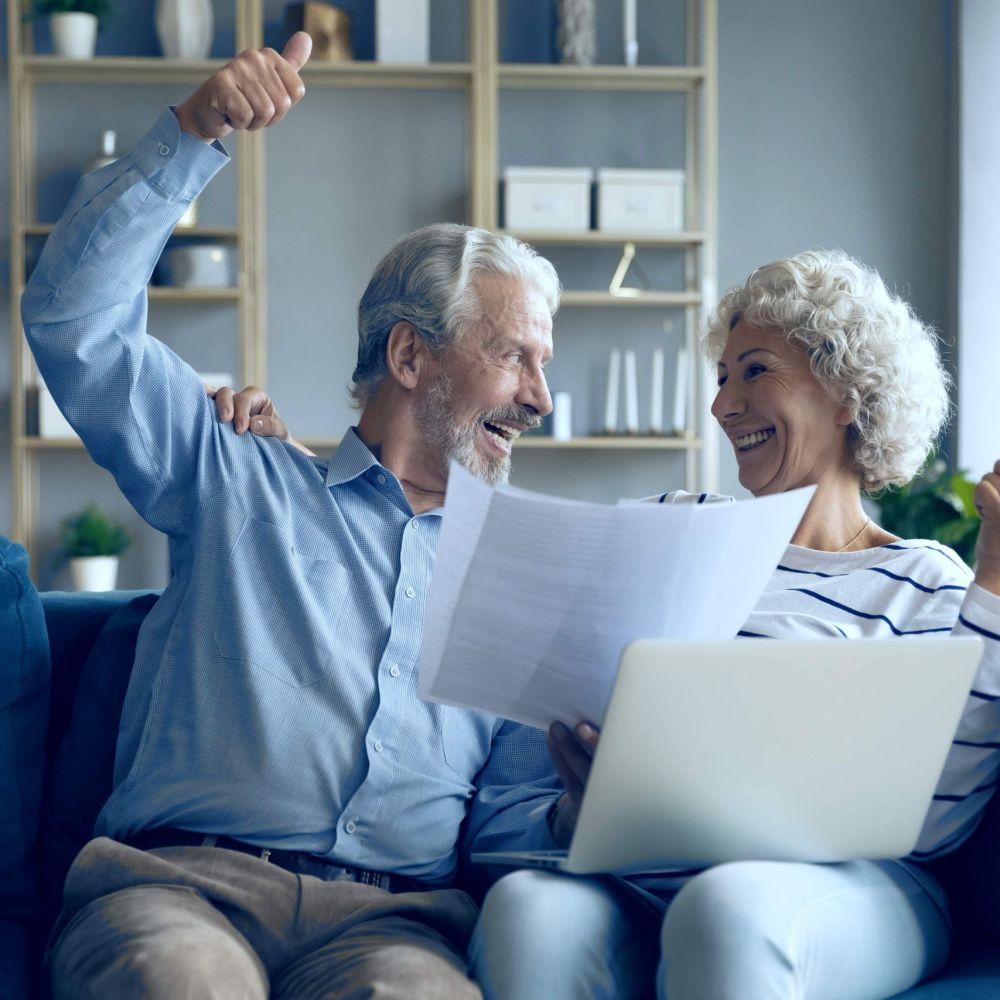 Senior couple celebrating successful tax debt resolution and IRS relief approval