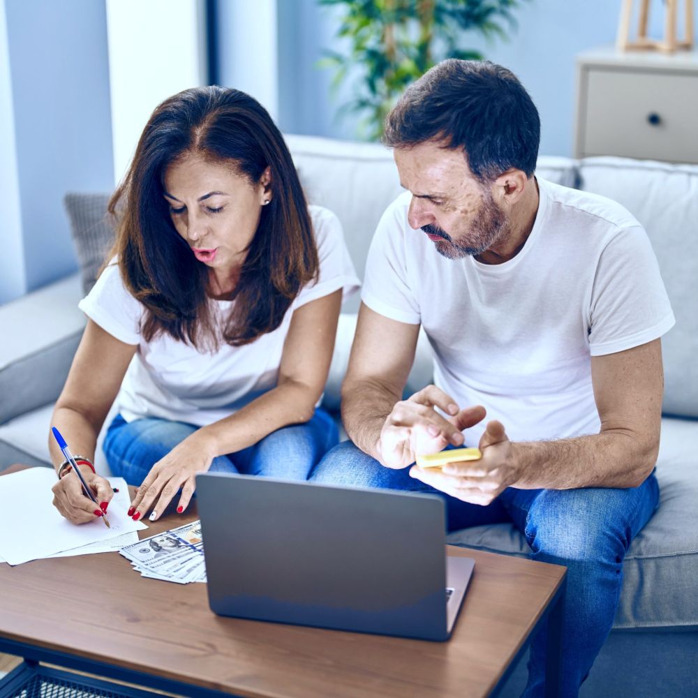 Couple reviewing tax debt paperwork and finances to qualify for IRS tax relief