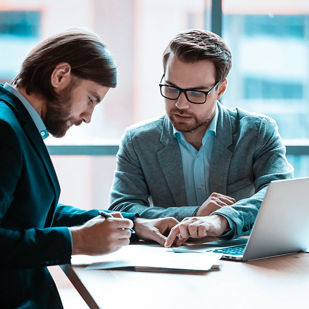 Tax attorney reviewing IRS debt relief contract with client in Long Beach